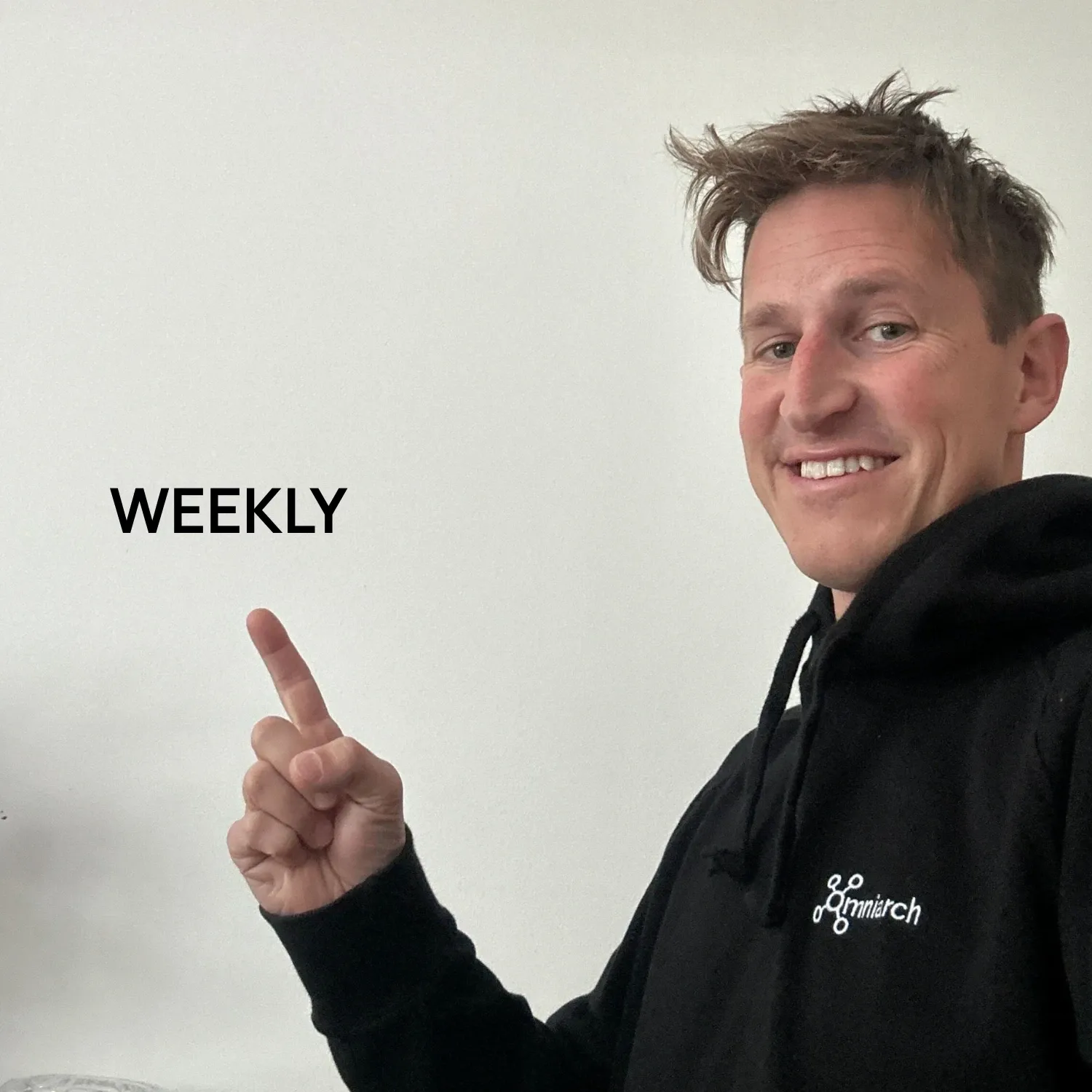 Pelle Pettersson i Omniarch-hoodie pekar på ordet WEEKLY